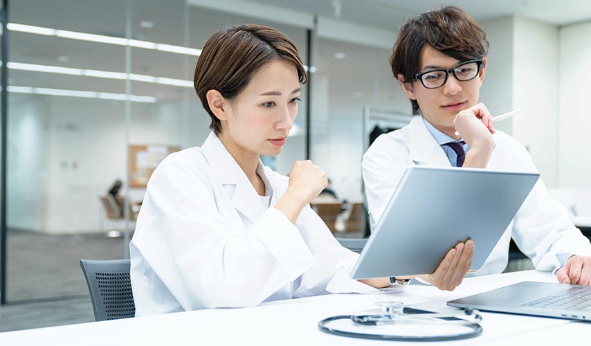 two scientists looking at a tablet